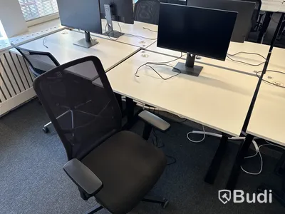 Höj- och sänkbart skrivbord med kontorsstol och datorskärm