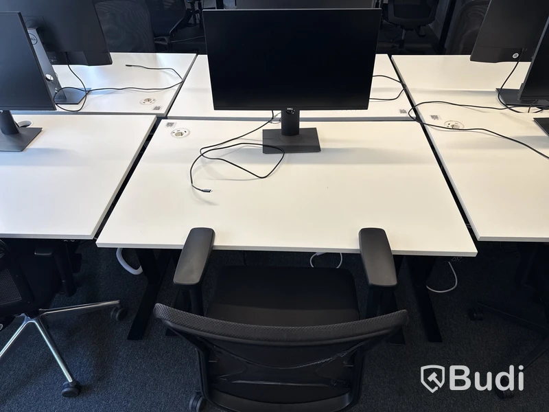 Höj- och sänkbart skrivbord med kontorsstol och datorskärm