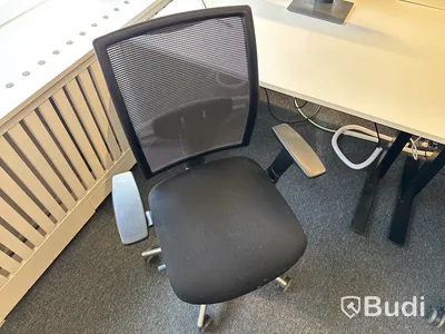 Höj- och sänkbart skrivbord med kontorsstol och datorskärm