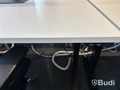 Höj- och sänkbart skrivbord med kontorsstol och datorskärm