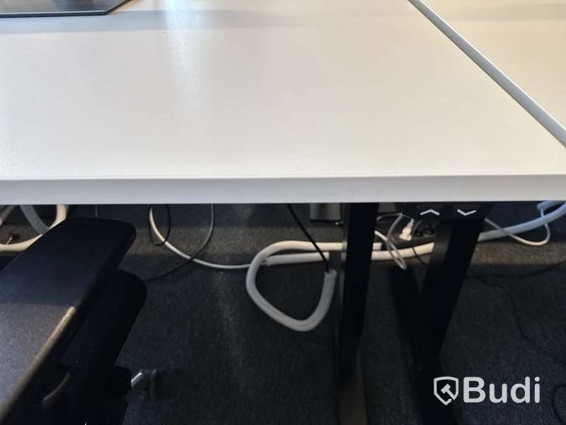 Höj- och sänkbart skrivbord med kontorsstol och datorskärm