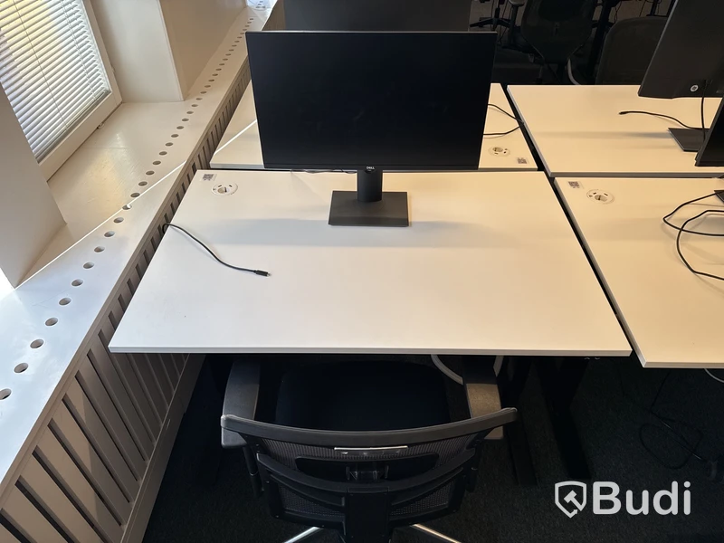 Höj- och sänkbart skrivbord med kontorsstol och datorskärm