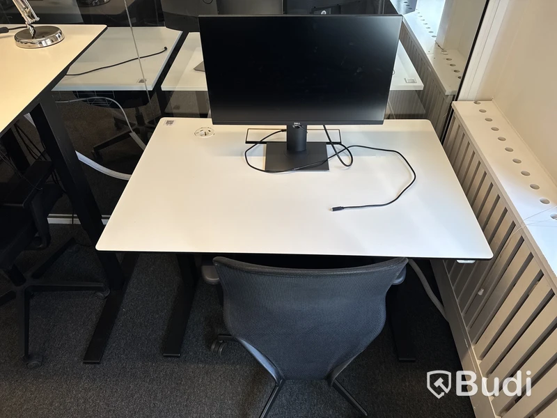 Höj- och sänkbart skrivbord med kontorsstol och datorskärm