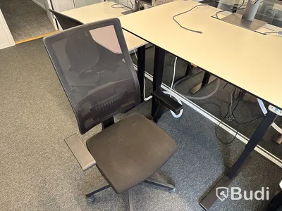 Höj- och sänkbart skrivbord med kontorsstol och datorskärm