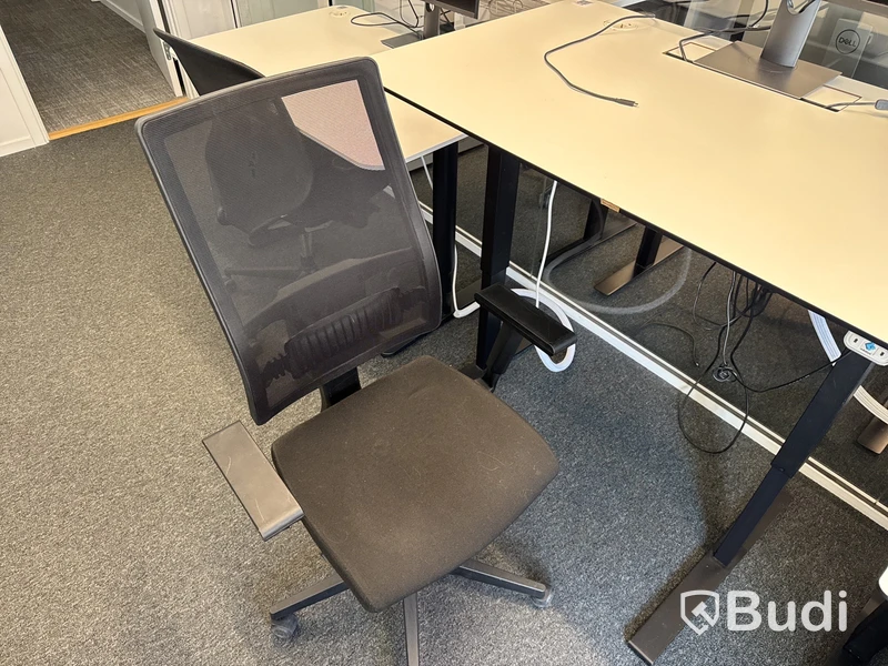 Höj- och sänkbart skrivbord med kontorsstol och datorskärm