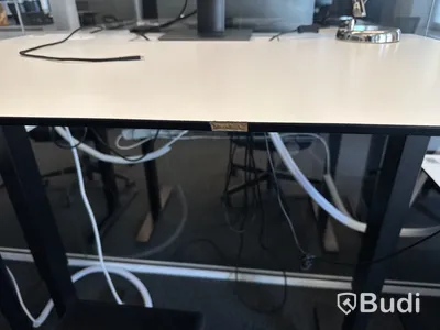 Höj- och sänkbart skrivbord med kontorsstol och datorskärm