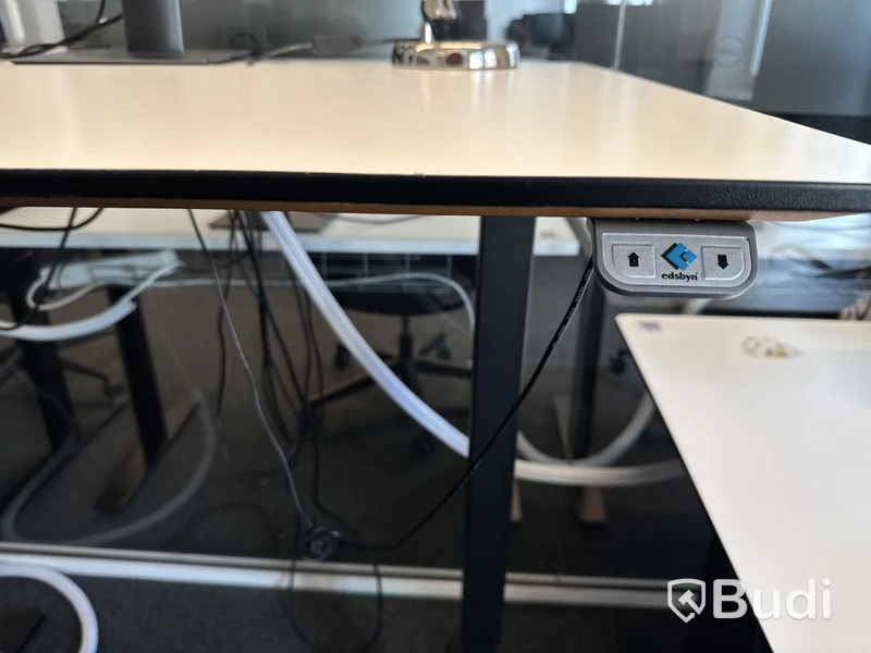 Höj- och sänkbart skrivbord med kontorsstol och datorskärm