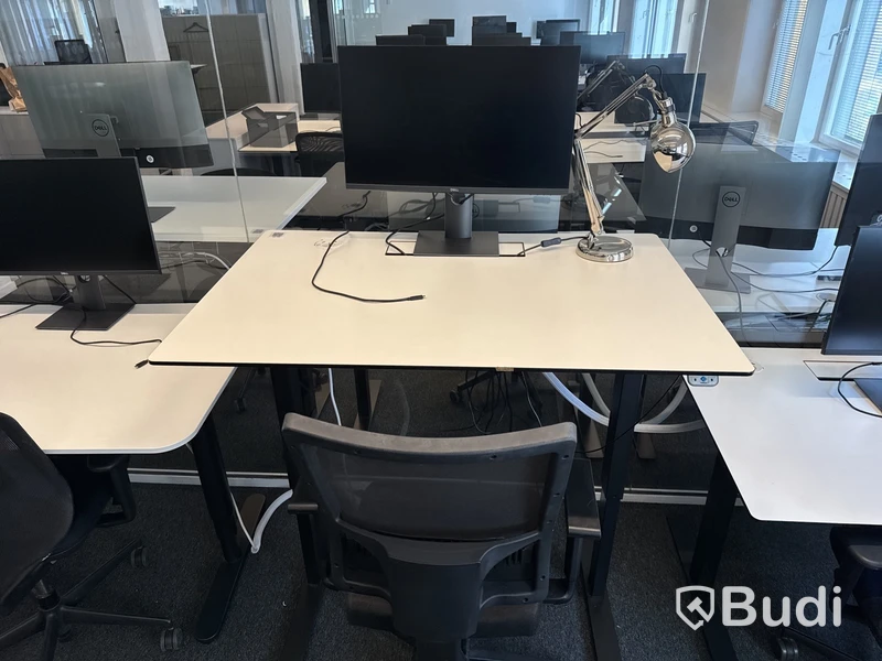 Höj- och sänkbart skrivbord med kontorsstol och datorskärm