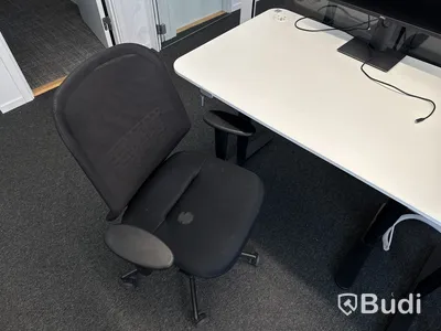 Höj- och sänkbart skrivbord med kontorsstol och datorskärm
