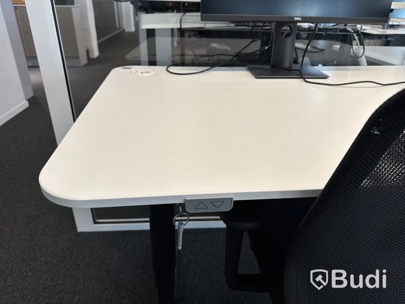 Höj- och sänkbart skrivbord med kontorsstol och datorskärm
