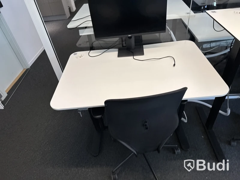 Höj- och sänkbart skrivbord med kontorsstol och datorskärm