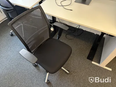 Höj- och sänkbart skrivbord med kontorsstol och datorskärm