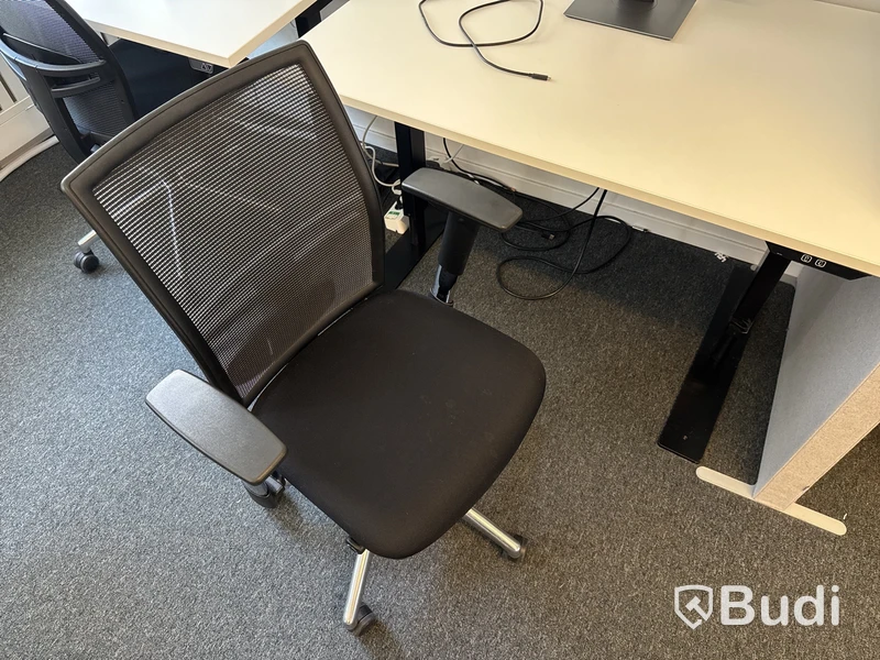 Höj- och sänkbart skrivbord med kontorsstol och datorskärm