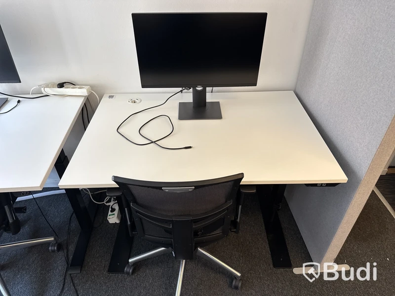 Höj- och sänkbart skrivbord med kontorsstol och datorskärm