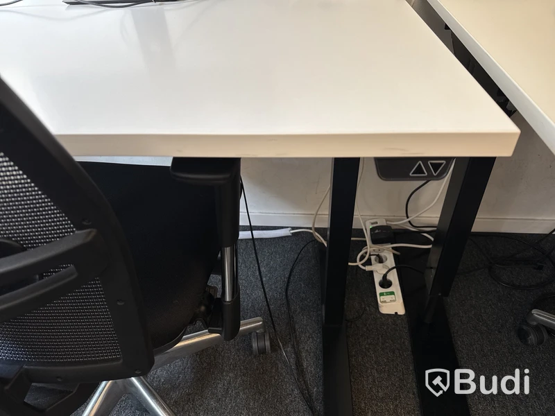 Höj- och sänkbart skrivbord med kontorsstol och datorskärm