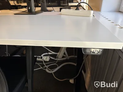 Höj- och sänkbart skrivbord med kontorsstol och datorskärm