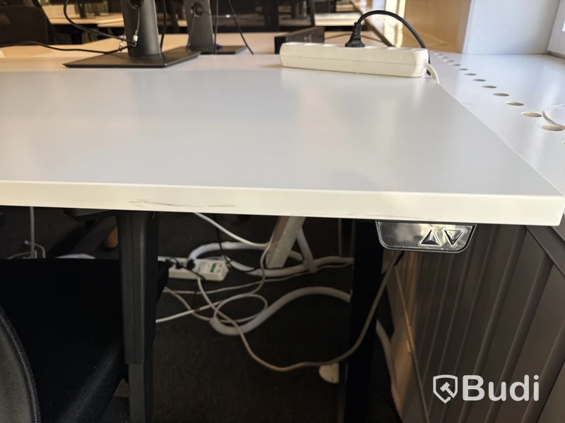 Höj- och sänkbart skrivbord med kontorsstol och datorskärm