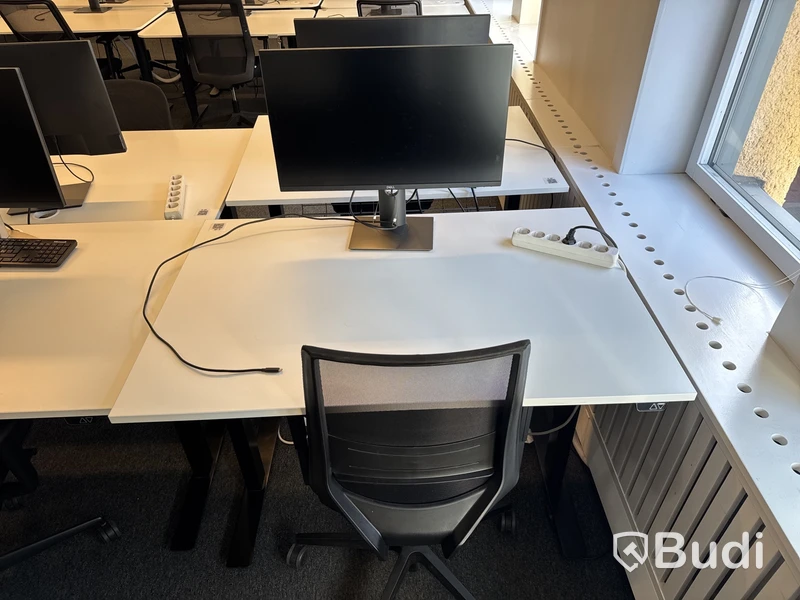 Höj- och sänkbart skrivbord med kontorsstol och datorskärm