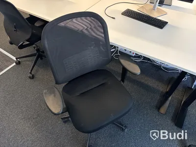 Höj- och sänkbart skrivbord med kontorsstol och datorskärm