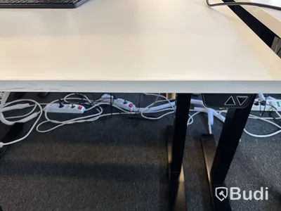 Höj- och sänkbart skrivbord med kontorsstol och datorskärm