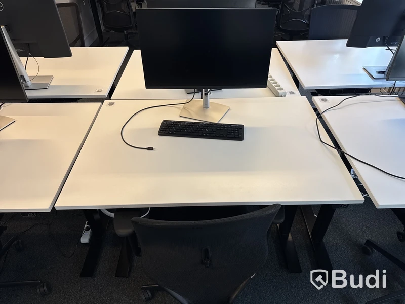Höj- och sänkbart skrivbord med kontorsstol och datorskärm