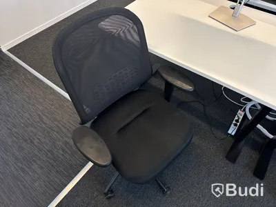 Höj- och sänkbart skrivbord med kontorsstol och datorskärm
