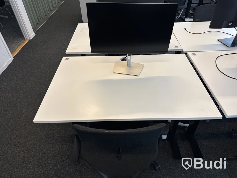 Höj- och sänkbart skrivbord med kontorsstol och datorskärm