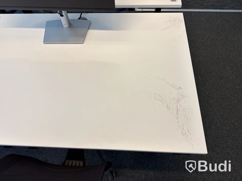 Höj- och sänkbart skrivbord med kontorsstol och datorskärm