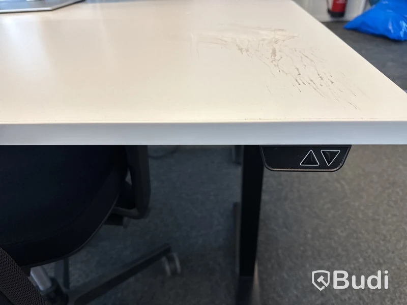 Höj- och sänkbart skrivbord med kontorsstol och datorskärm