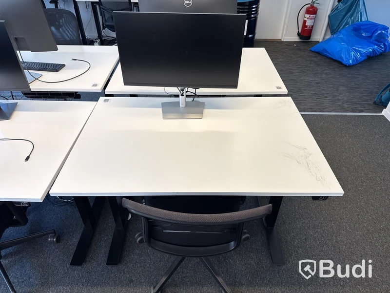 Höj- och sänkbart skrivbord med kontorsstol och datorskärm