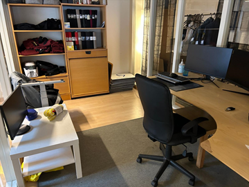 Kontorsrum med skrivbord, stolar, bord, förvaring, datorskärmar, skrivare