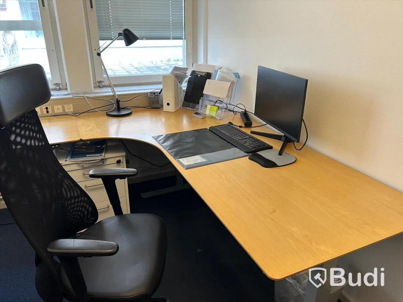Kontorsrum med skrivbord, skrivbordsstol, förvaring, datorskärm, besöksstol