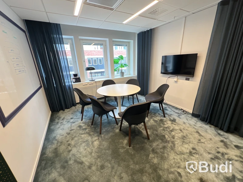 Bord, 6 stolar, 3 st blå gardiner i olika längd, 1 grön tavla, 1 lampa och 1 plastväxt