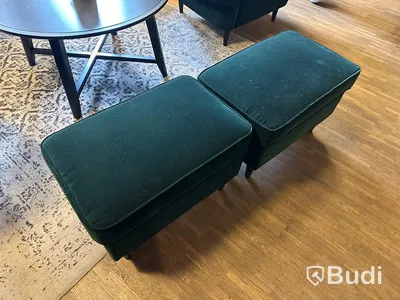 Möbelgrupp med fåtöljer, soffbord, lampa och matta.