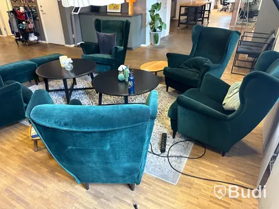 Möbelgrupp med fåtöljer, soffbord, lampa och matta.