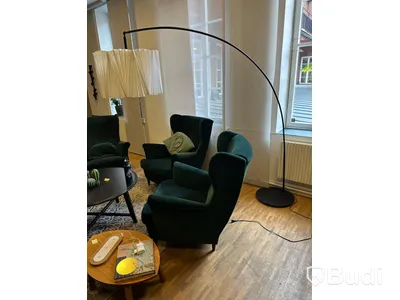 Möbelgrupp med fåtöljer, soffbord, lampa och matta.