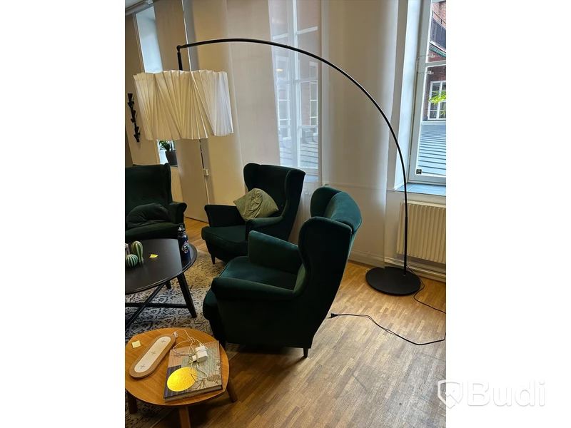 Möbelgrupp med fåtöljer, soffbord, lampa och matta.