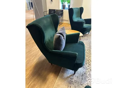 Möbelgrupp med fåtöljer, soffbord, lampa och matta.