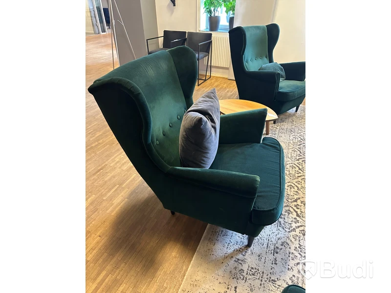 Möbelgrupp med fåtöljer, soffbord, lampa och matta.