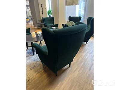 Möbelgrupp med fåtöljer, soffbord, lampa och matta.
