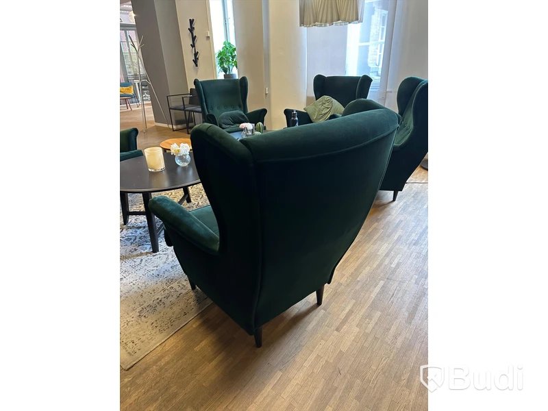 Möbelgrupp med fåtöljer, soffbord, lampa och matta.