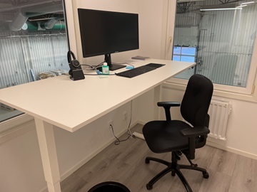 Höj- och sänkbart skrivbord med kontorsstol, skärm och tangentbord