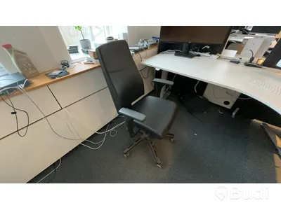 Skrivbord, skåp, skrivare och stol.