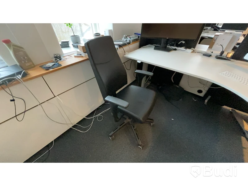Skrivbord, skåp, skrivare och stol.