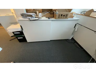 Skrivbord, skåp, skrivare och stol.
