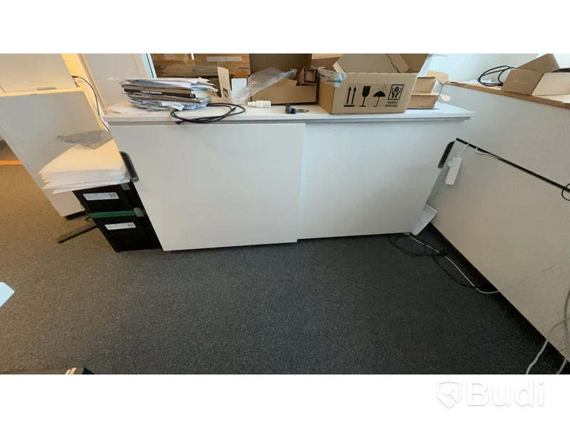 Skrivbord, skåp, skrivare och stol.