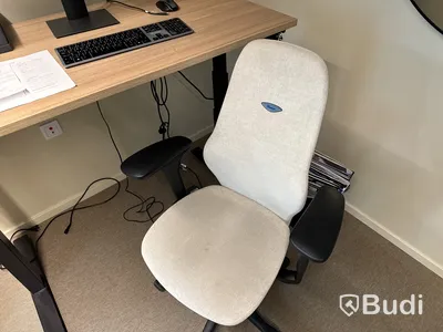 Höj- och sänkbart skrivbord med kontorsstol och datorskärm