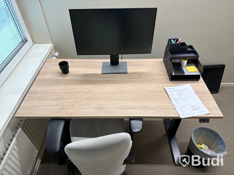 Höj- och sänkbart skrivbord med kontorsstol och datorskärm