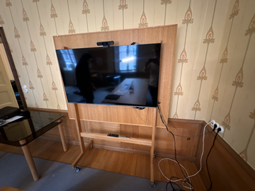 TV med konferensutrustning på stativ med whiteboard-tavla