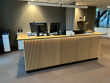 Receptionsdisk, design av Emil Lind med elektriskt höj- & sänkbara skrivbord, datorskärmar, stolar